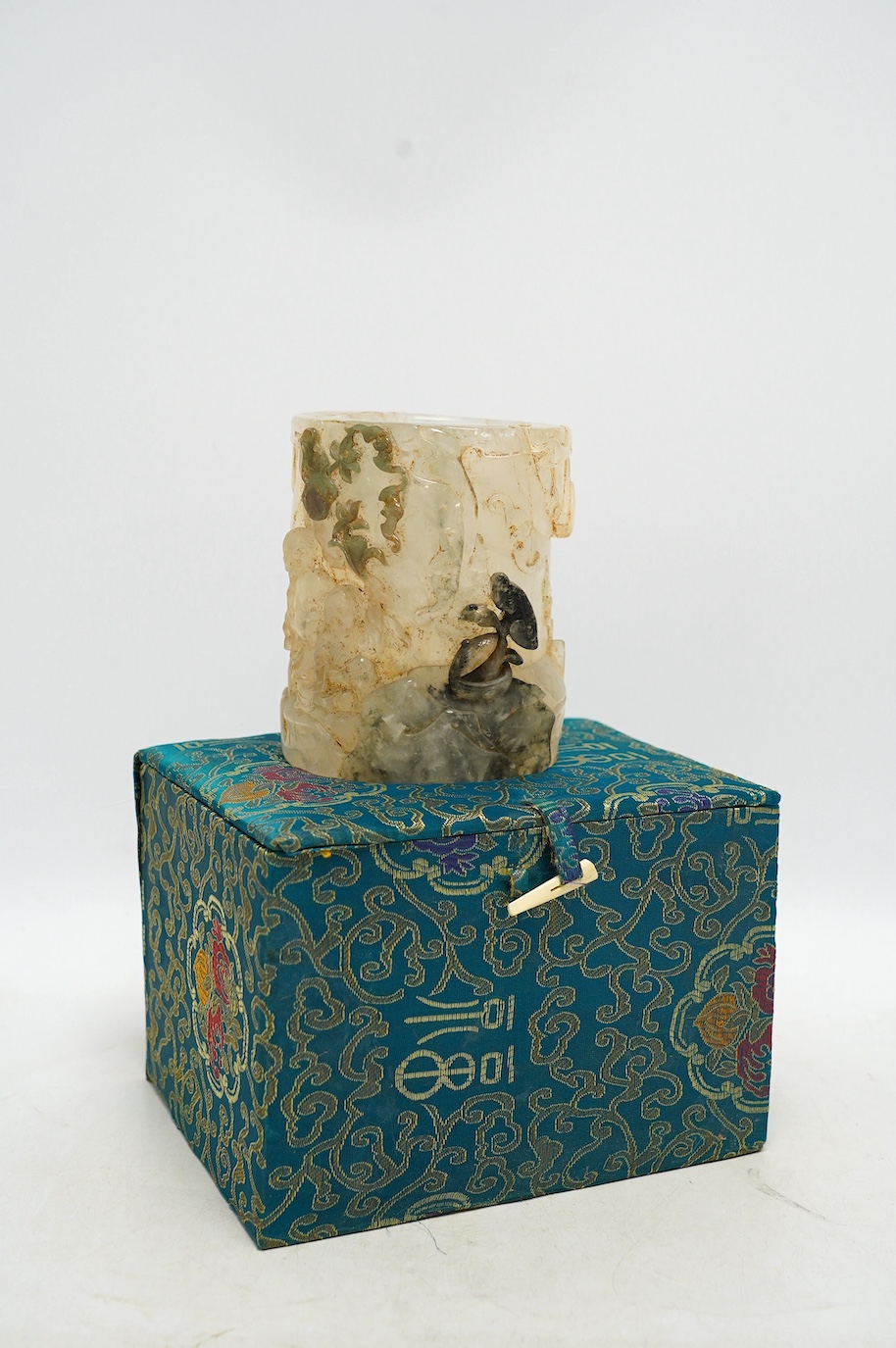 A Chinese quartz brushpot carved with figures before a landscape, cased, 14cm high. Condition - good